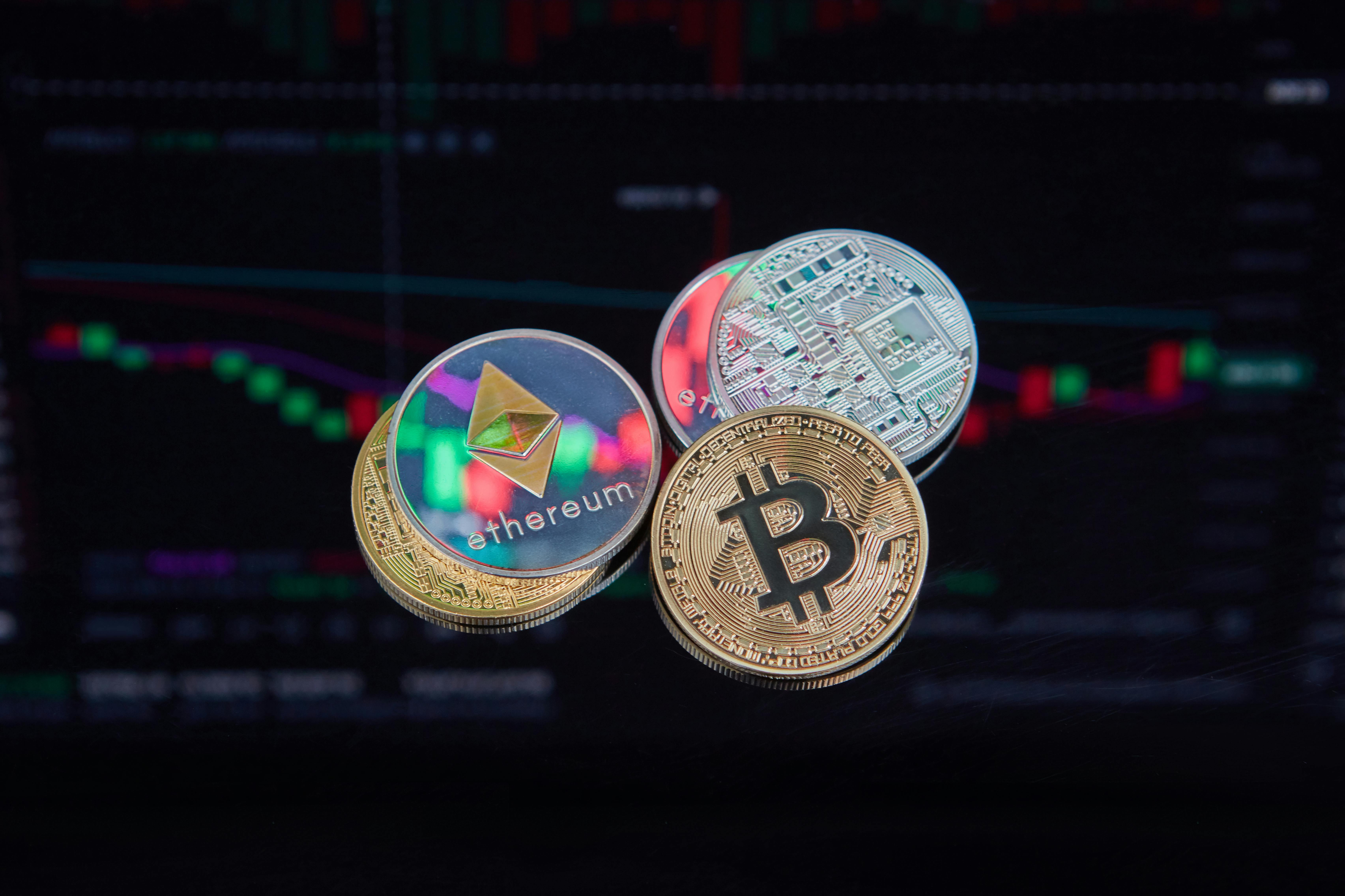 Ethereum and Bitcoin coins in front of a crypto market chart